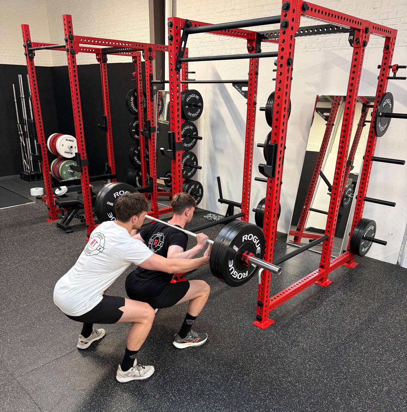 Personal trainer in Leuven begeleidt squat techniek tijdens krachttraining