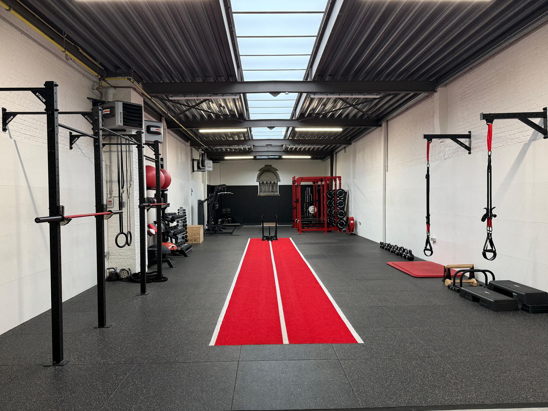 Private gym in Leuven met rode trainingsbaan en krachtmateriaal